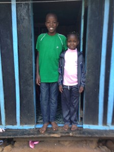 Abigael and her brother outside their home.